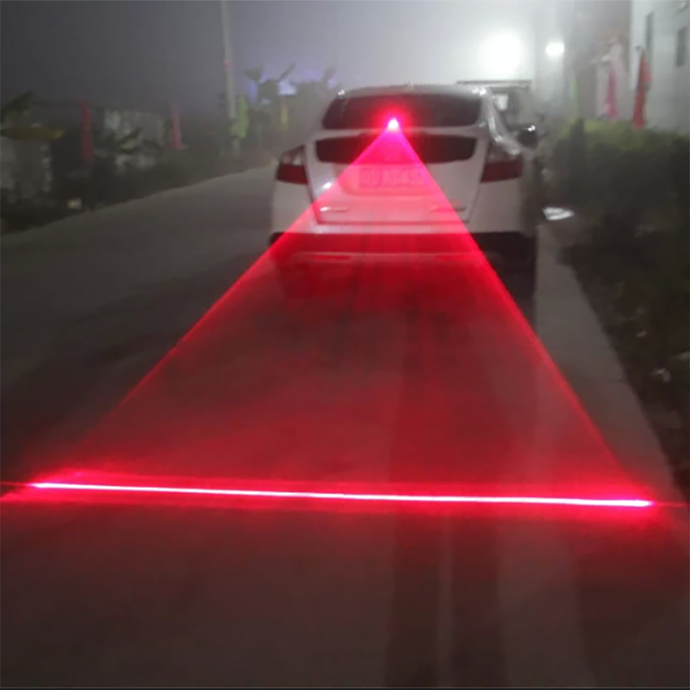 Luz láser anticolisión roja proyectada en la calle detrás de un auto